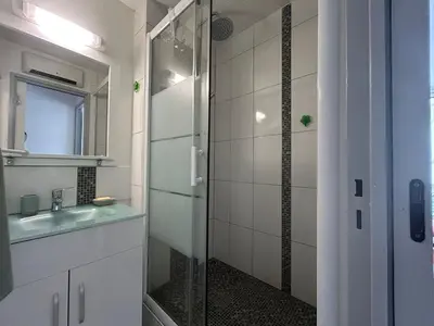 a bathroom with a glass shower and a sink at Le Ponant - Appartement proche du port et de la mer in Gruissan