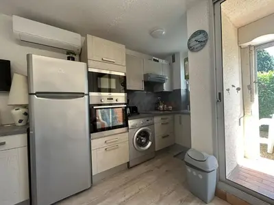 a kitchen with a refrigerator and a washing machine at Le Ponant - Appartement proche du port et de la mer in Gruissan