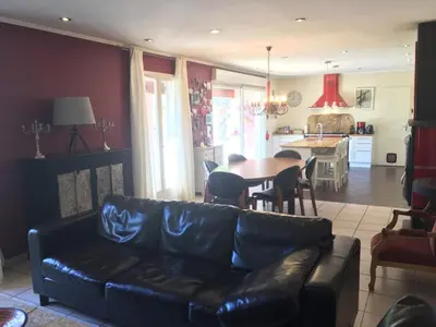 a living room with a leather couch and a table at Villa privée Un vrai havre de paix in Limoux