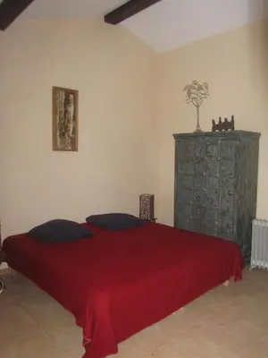 a bedroom with a bed with a red blanket at Villa privée Un vrai havre de paix in Limoux