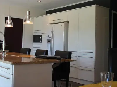 a kitchen with a counter with chairs and a refrigerator at Villa privée Un vrai havre de paix in Limoux