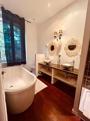 a bathroom with a large tub and two sinks at chateau Laprade Narbonne in Narbonne