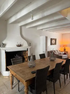 a dining room with a wooden table and a couch at chateau Laprade Narbonne in Narbonne