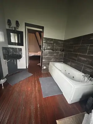 a bathroom with a white tub and a wooden floor at chateau Laprade Narbonne in Narbonne