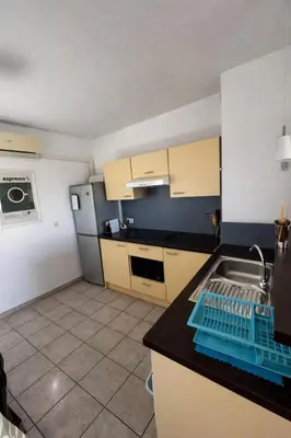 a kitchen with a sink and a counter top at Résidence Les jardins du Phoebus Géolia Piscine Climatisation Parking By LCG in Gruissan