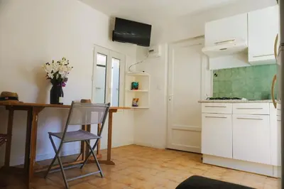 a kitchen with a table and a chair in a room at La Dorade du port in Port-la-Nouvelle