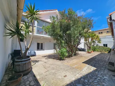 a house with trees and plants in a courtyard at La Dorade du port in Port-la-Nouvelle