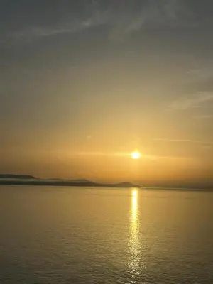 a sunset over the water with the sun in the sky at La Dorade du port in Port-la-Nouvelle