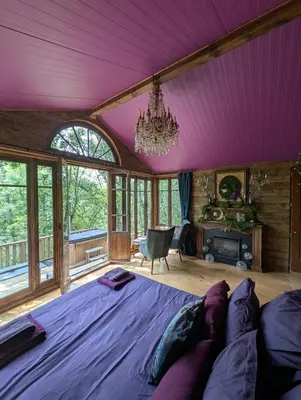 a bedroom with a large bed with purple ceilings at Cabane d'Oniria in Palaja