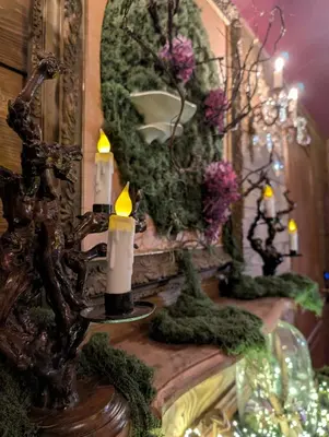 a table with candles and a mirror and flowers at Cabane d'Oniria in Palaja