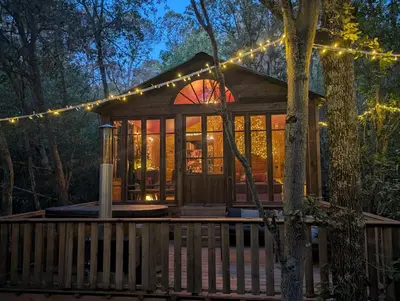 a cabin in the woods with christmas lights at Cabane d'Oniria in Palaja