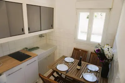a small kitchen with a table and a table and chairs at L'anguille du port clim jardin mer in Port-la-Nouvelle