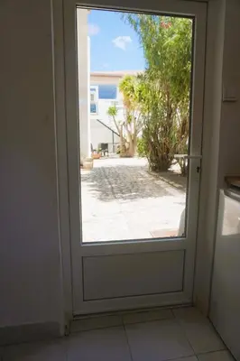 an open door with a view of a patio at L'anguille du port clim jardin mer in Port-la-Nouvelle
