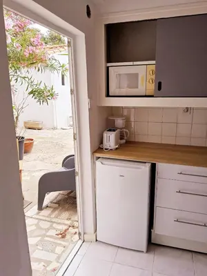 a kitchen with a white refrigerator and a microwave at L'anguille du port clim jardin mer in Port-la-Nouvelle