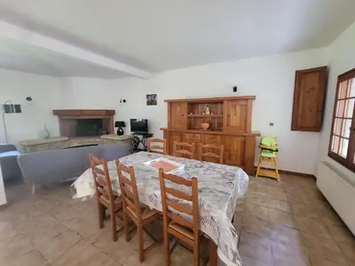 a dining room with a table and a kitchen at maison de campagne in Le Vernet