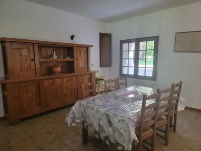a dining room with a table and wooden cabinets at maison de campagne in Le Vernet