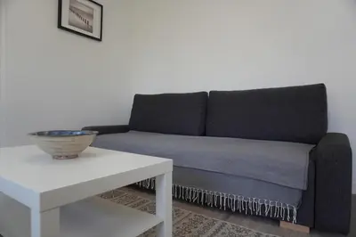 a couch sitting in a living room next to a table at Le Dauphin du port in Port-la-Nouvelle