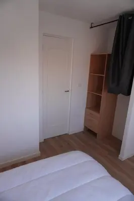 a bedroom with a white bed and a closet at Le Dauphin du port in Port-la-Nouvelle