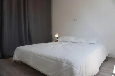 a white bed with two pillows on top of it at Le Dauphin du port in Port-la-Nouvelle