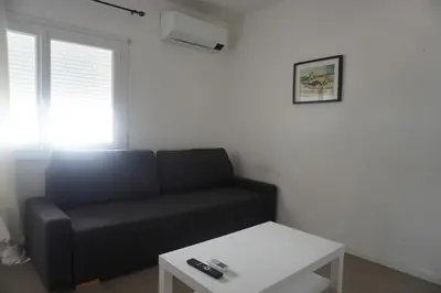 a living room with a black couch and a table at L'espadon du port, air conditioning, terrace, sea, 5 people in Port-la-Nouvelle
