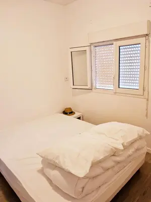 a white bedroom with a bed and a window at L'espadon du port, air conditioning, terrace, sea, 5 people in Port-la-Nouvelle