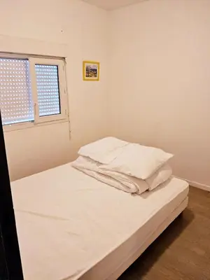a bed with white sheets and pillows in a room at L'espadon du port, air conditioning, terrace, sea, 5 people in Port-la-Nouvelle