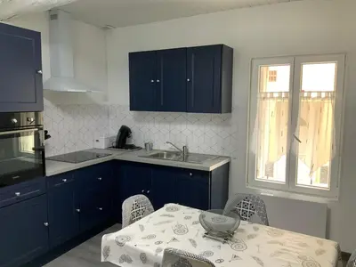 a kitchen with blue cabinets and a table and a sink at les gites de KALY in Bélesta
