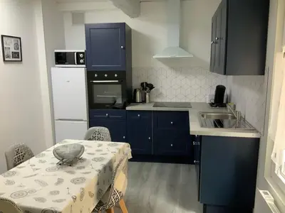 a kitchen with a table and a kitchen with blue cabinets at les gites de KALY in Bélesta