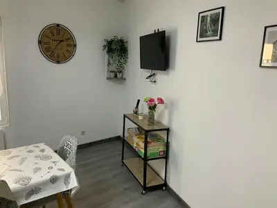 a room with a table and a clock on a wall at les gites de KALY in Bélesta
