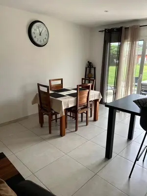 a dining room with a table and a clock on the wall at David in La Tour-du-Crieu
