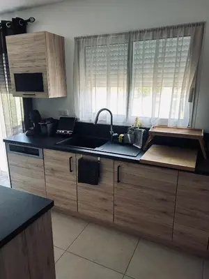 a kitchen with wooden cabinets and a sink and a window at David in La Tour-du-Crieu