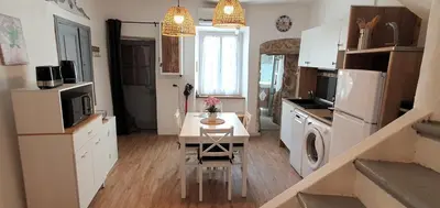 a small kitchen with a table and a microwave at La Biscornutte in Thézan-des-Corbières