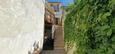 a stairway leading up to a building with a green hedge at La Biscornutte in Thézan-des-Corbières