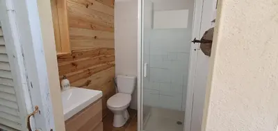 a bathroom with a toilet and a glass shower door at La Biscornutte in Thézan-des-Corbières
