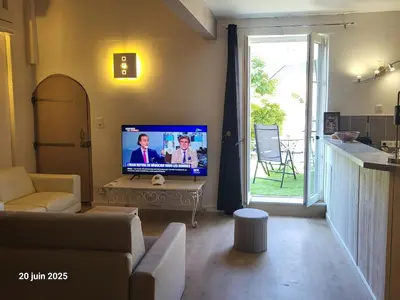 a large bed in a room with a couch and a tv at Gîte Coté Village - le cœur du village avec piscine in Salles-d'Aude
