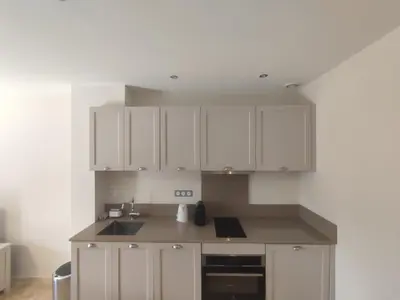 a kitchen with white cabinets and a sink at Villa Élegancia - Piscine privé - Wifi - 18 in La Redorte