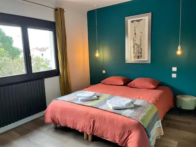 a bedroom with a large bed with red sheets at Artistic house in Carcassonne