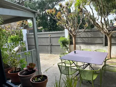 a table and chairs in a backyard with plants at Artistic house in Carcassonne