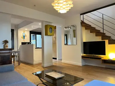 a living room with a television and a staircase at Artistic house in Carcassonne