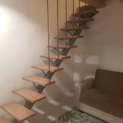 a set of wooden stairs in a living room with a couch at Peyriac de Mer House in Peyriac-de-Mer