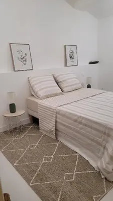 a white bedroom with a large bed and a table at Peyriac de Mer House in Peyriac-de-Mer