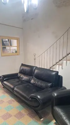 a black leather couch sitting in a room at Peyriac de Mer House in Peyriac-de-Mer