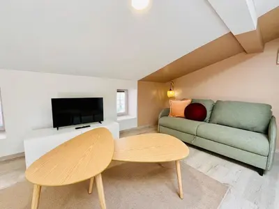a living room with a couch and a table at L'escale cocoon - cozy and relaxing in Villefranche-de-Lauragais