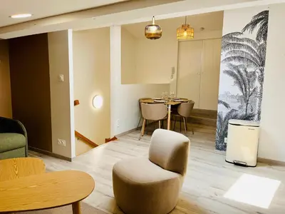 a living room with a table and a chair at L'escale cocoon - cozy and relaxing in Villefranche-de-Lauragais