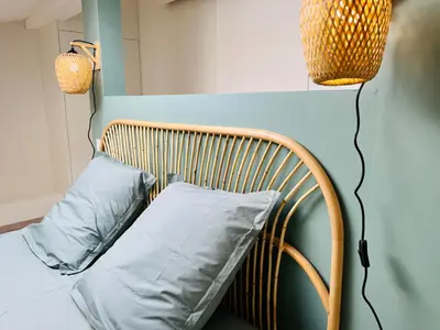 a bed with two blue pillows and two lights at L'escale cocoon - cozy and relaxing in Villefranche-de-Lauragais