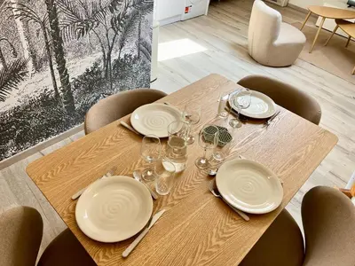 a wooden table with plates and wine glasses on it at L'escale cocoon - cozy and relaxing in Villefranche-de-Lauragais