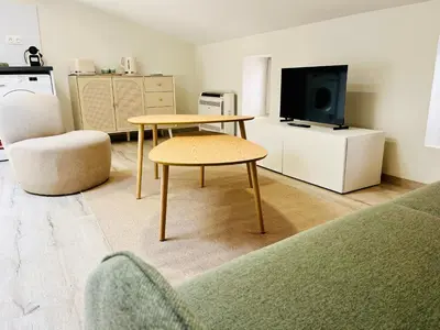 a living room with a table and a tv at L'escale cocoon - cozy and relaxing in Villefranche-de-Lauragais