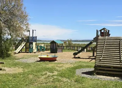 a small boat sitting on the ground in a playground at Maison bleu avec vue mer, étang & Pyrénées in Bages