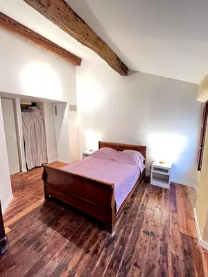a bedroom with a bed and a wooden floor at Maison de village pleine de charme, 7 couchages in Vingrau