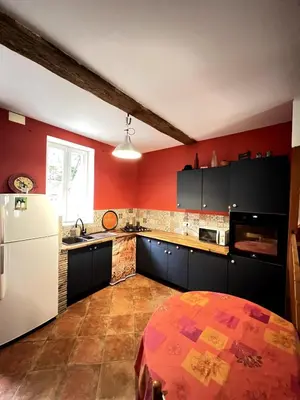 a kitchen with red walls and a white refrigerator at Maison de village pleine de charme, 7 couchages in Vingrau